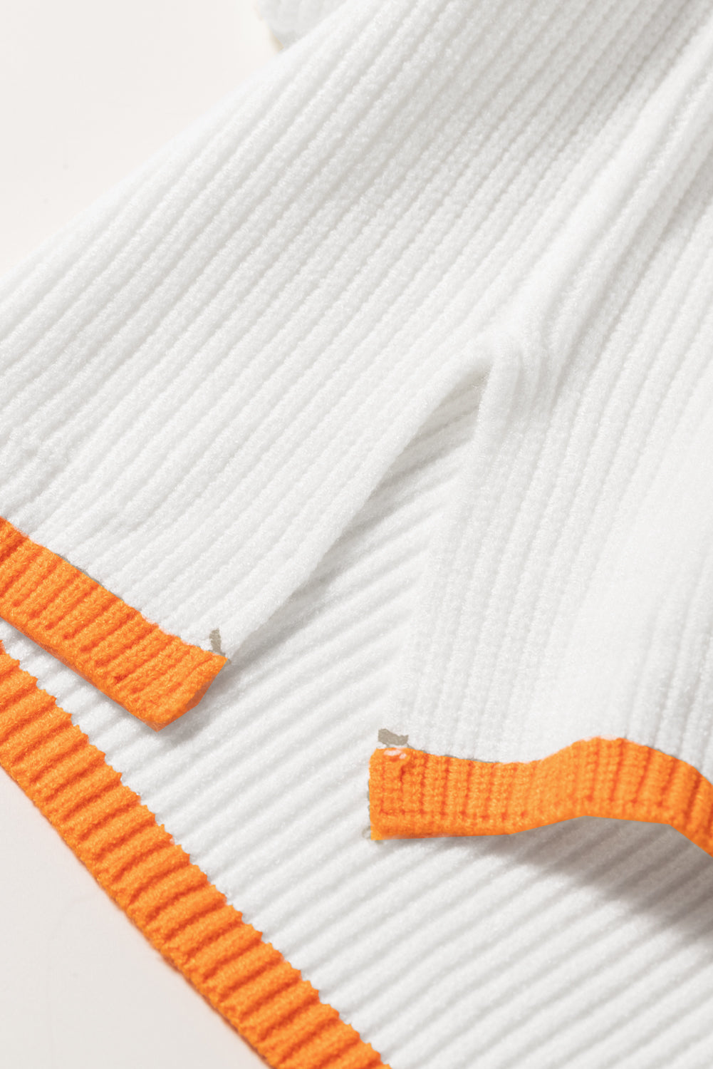 Weißer Pullover mit Viertelreißverschluss und überschnittener Schulterpartie mit buntem Rand