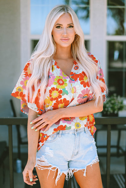 Orangefarbene Bluse mit V-Ausschnitt und halblangen Ärmeln und abstraktem Print