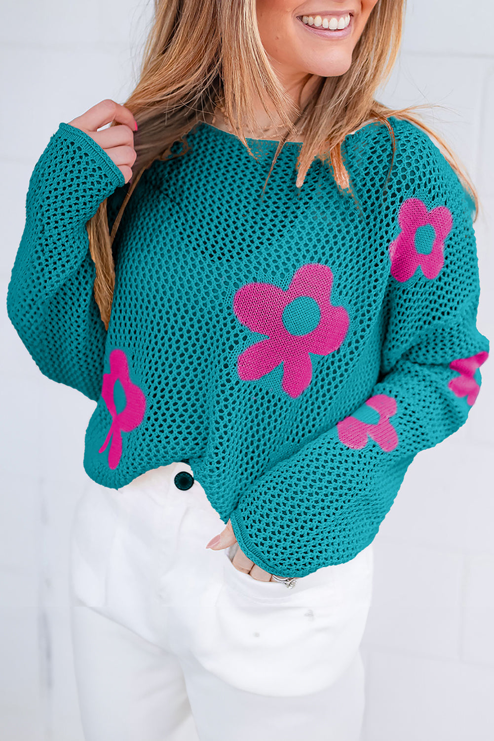 Seegrüner Strickpullover mit großer Blume und tief angesetzten Schultern
