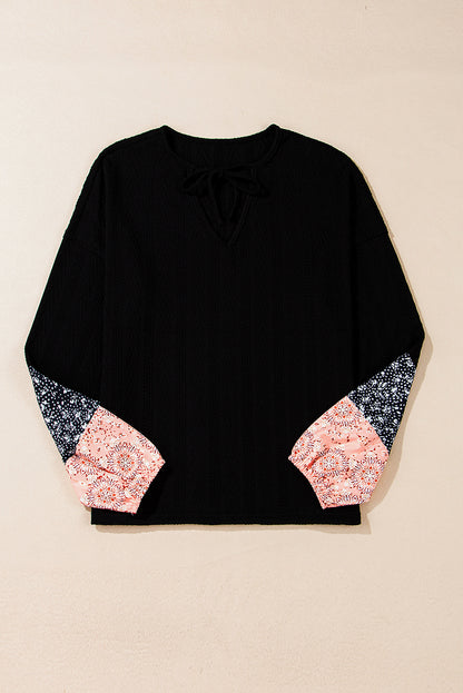 Schwarze Bluse mit V-Ausschnitt und floralem Patchwork-Muster