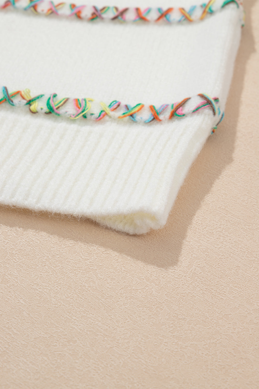 Weißer Pullover mit bunten Kreuzstichen und überschnittenen Schultern