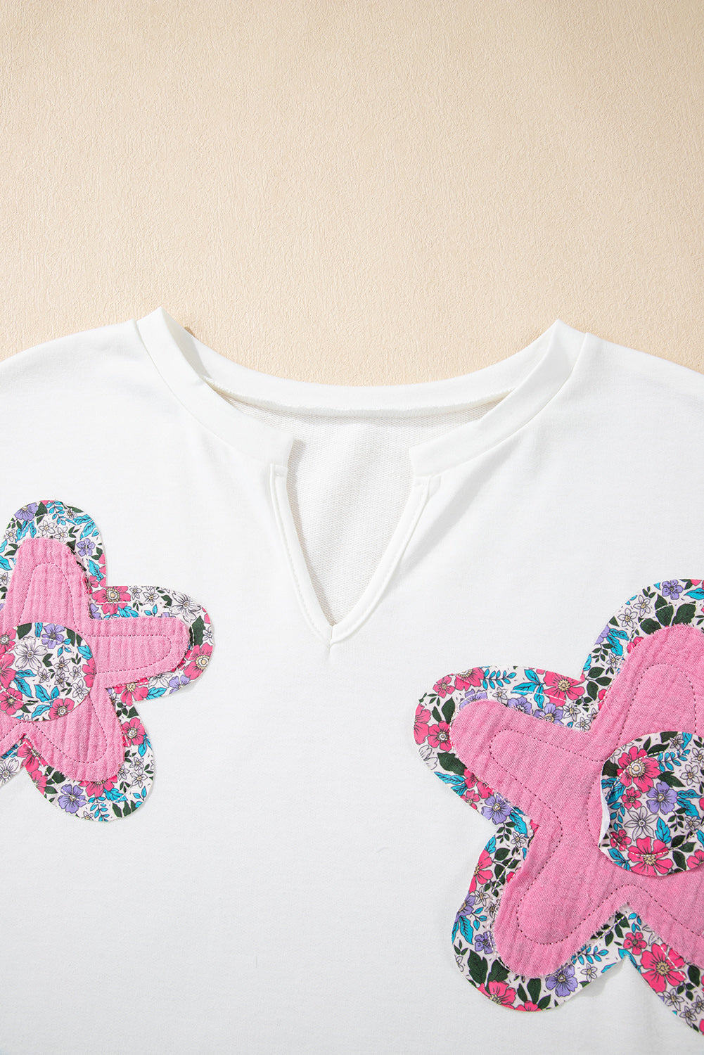 Weißes Top mit V-Ausschnitt und Dolman-Ärmeln und Blumenapplikation