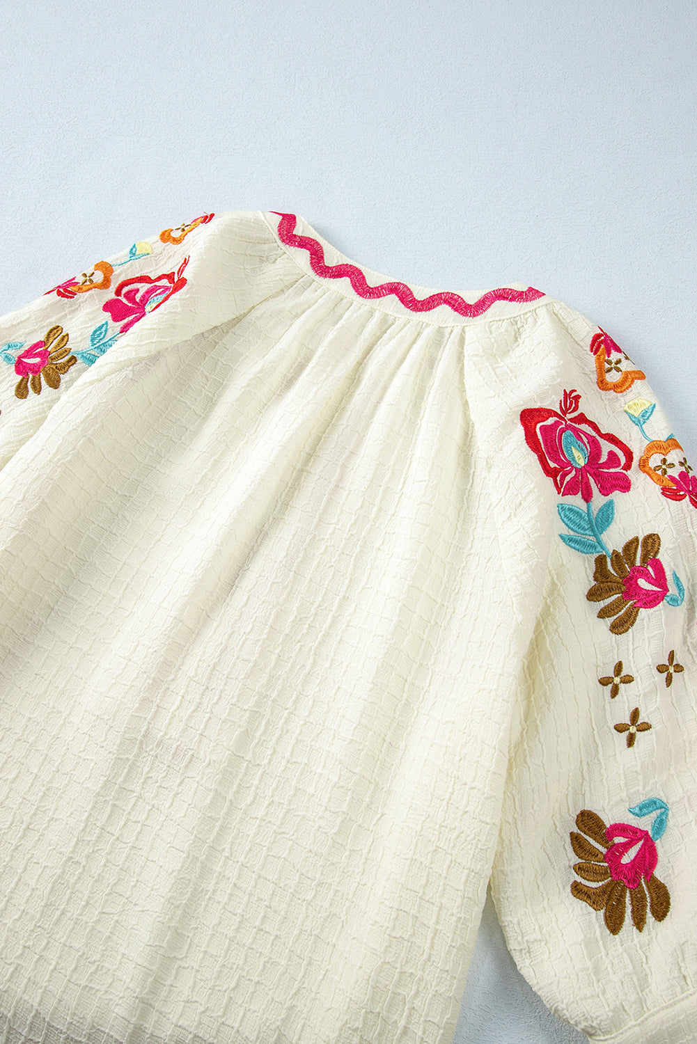 Beigefarbene Bluse mit floraler Stickerei und strukturierten Puffärmeln im Ricrac-Stil