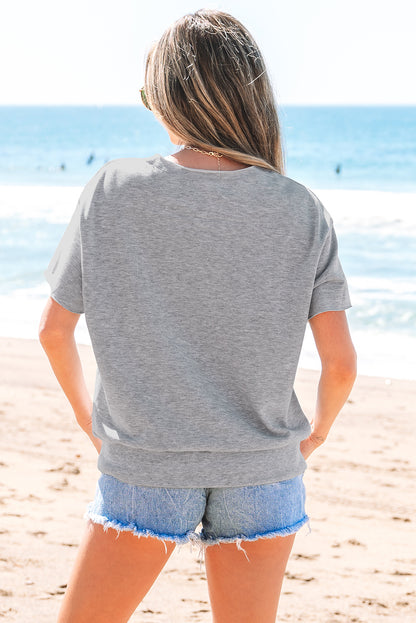 Hellgraues, lockeres T-Shirt mit USA-Schriftzug-Patch und eingekerbtem Ausschnitt