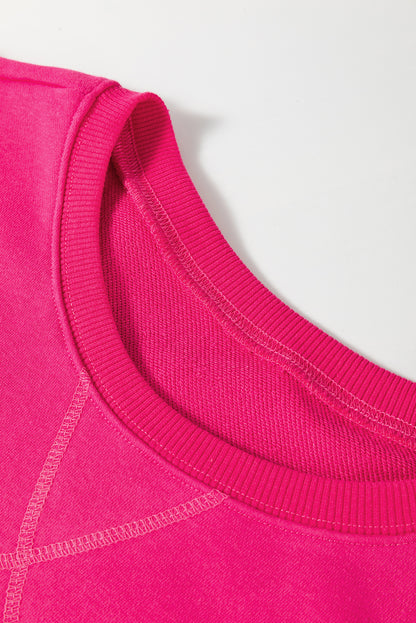 Rosarotes, lockeres Sweatshirt mit überschnittenen Schultern, überkreuzten Nähten und Taschen