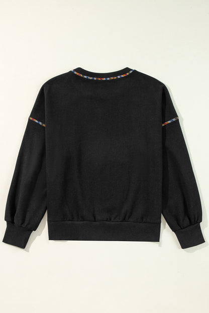 Schwarzes Pullover-Sweatshirt mit überschnittener Schulter und kontrastierendem Regenbogenbesatz