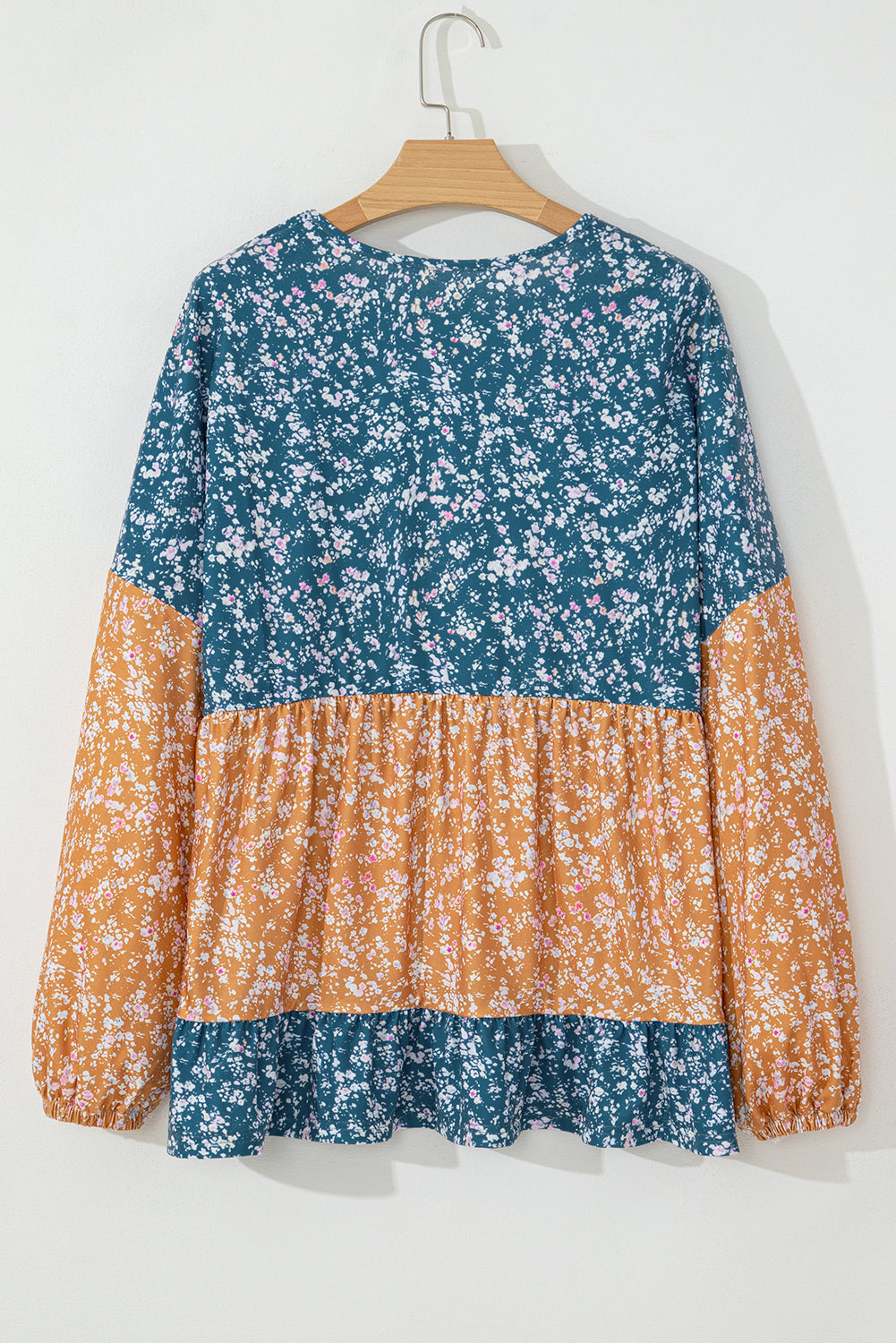 Orangefarbene Bluse mit Blumenmuster, Farbblockdesign, Rüschensaum und Rundhalsausschnitt