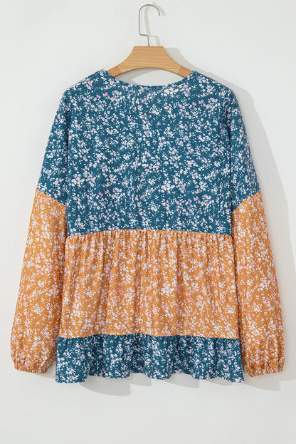 Orangefarbene Bluse mit Blumenmuster, Farbblockdesign, Rüschensaum und Rundhalsausschnitt