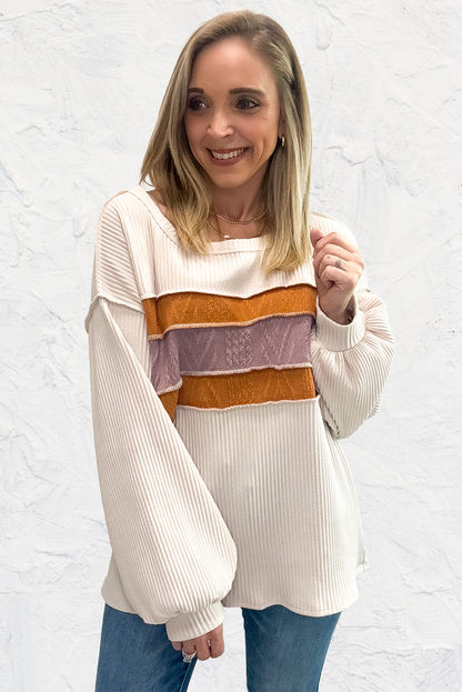Weißes Stricktop mit Patchwork-Muster und sichtbaren Nähten sowie langen Ärmeln