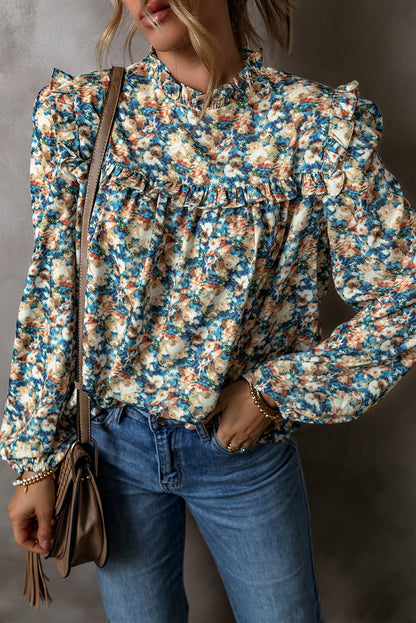 Himmelblaue Bluse mit Blumenmuster, Rüschen und Stehkragen sowie Puffärmeln