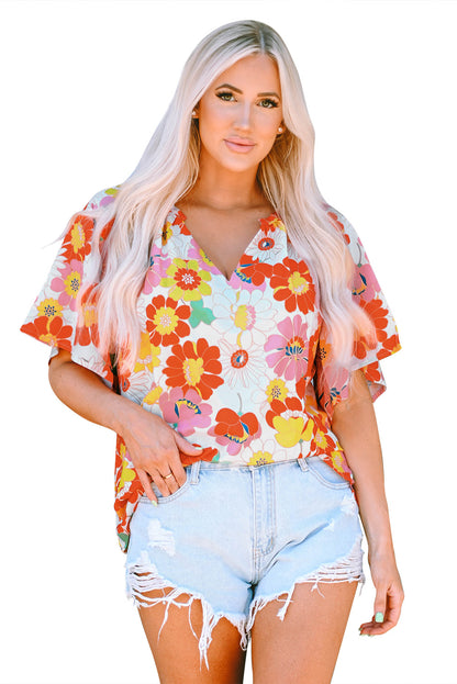 Orangefarbene Bluse mit V-Ausschnitt und halblangen Ärmeln und abstraktem Print