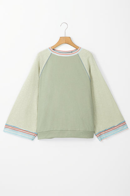 Meadow Mist – Grünes Waffelstrick-Patchwork-Raglan-Top mit breiten Armbandärmeln