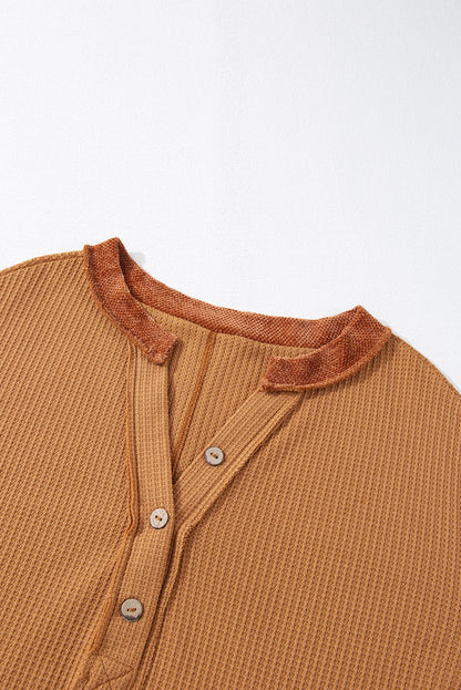 Orangefarbenes Henley-Oberteil aus Waffelstrick mit kontrastierenden Flicken und sichtbaren Nähten
