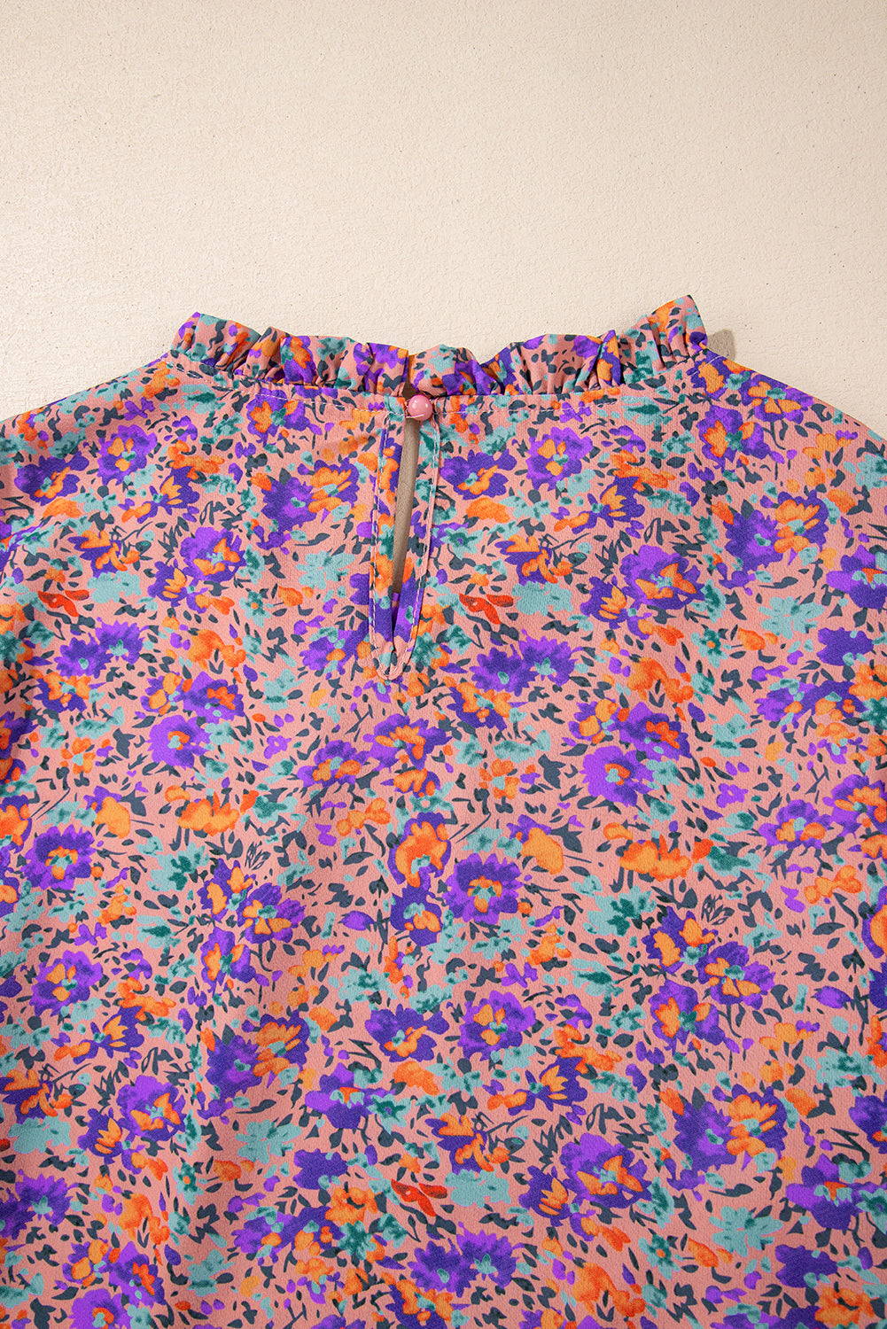 Lila Bluse mit Rundhalsausschnitt, Blumenmuster und gerafften Bündchen