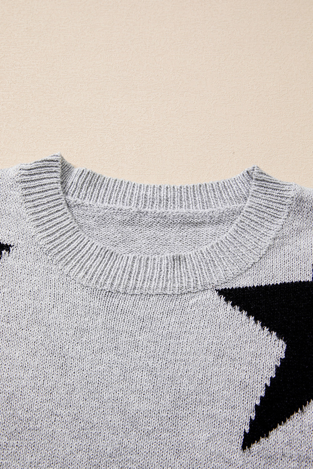 Grauer Pullover mit überschnittener Schulter und Sternmuster