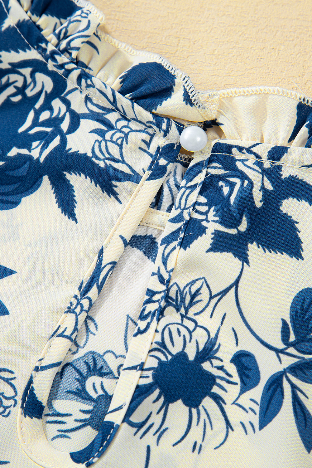 Himmelblaue Bluse mit Blumenmuster, Volantärmeln und Schlüsselloch hinten