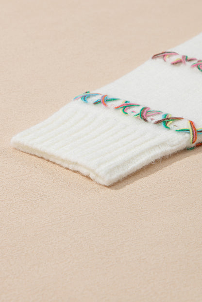 Weißer Pullover mit bunten Kreuzstichen und überschnittenen Schultern