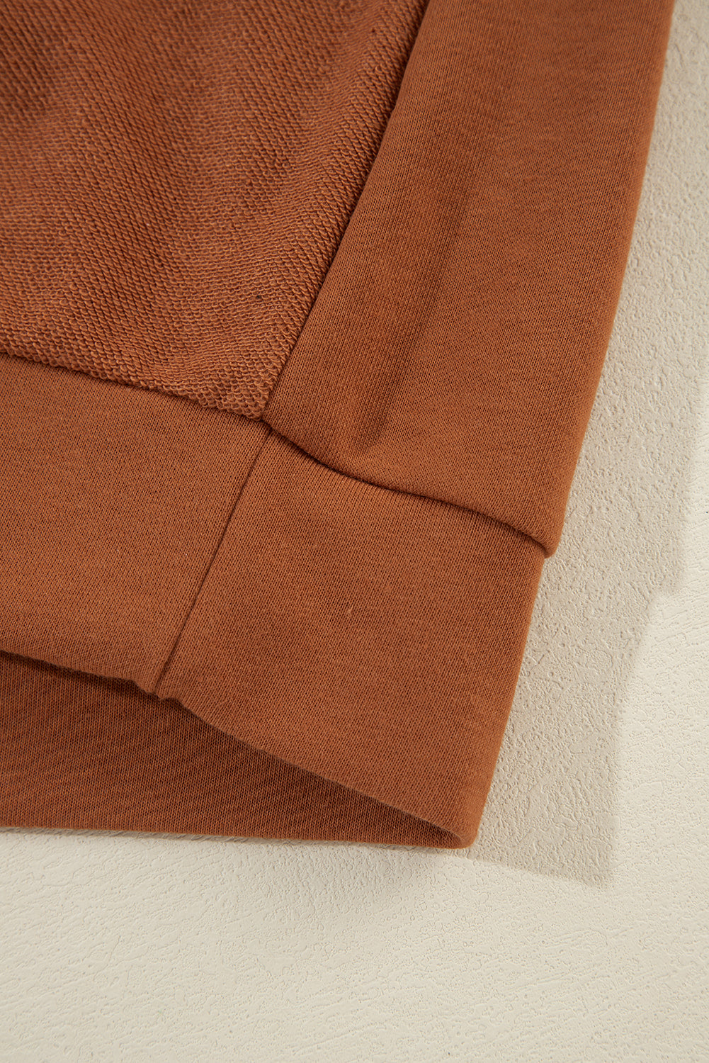 Zimtfarbener Kapuzenpullover mit sichtbaren Nähten und kalter Schulterpartie und Kordelzug