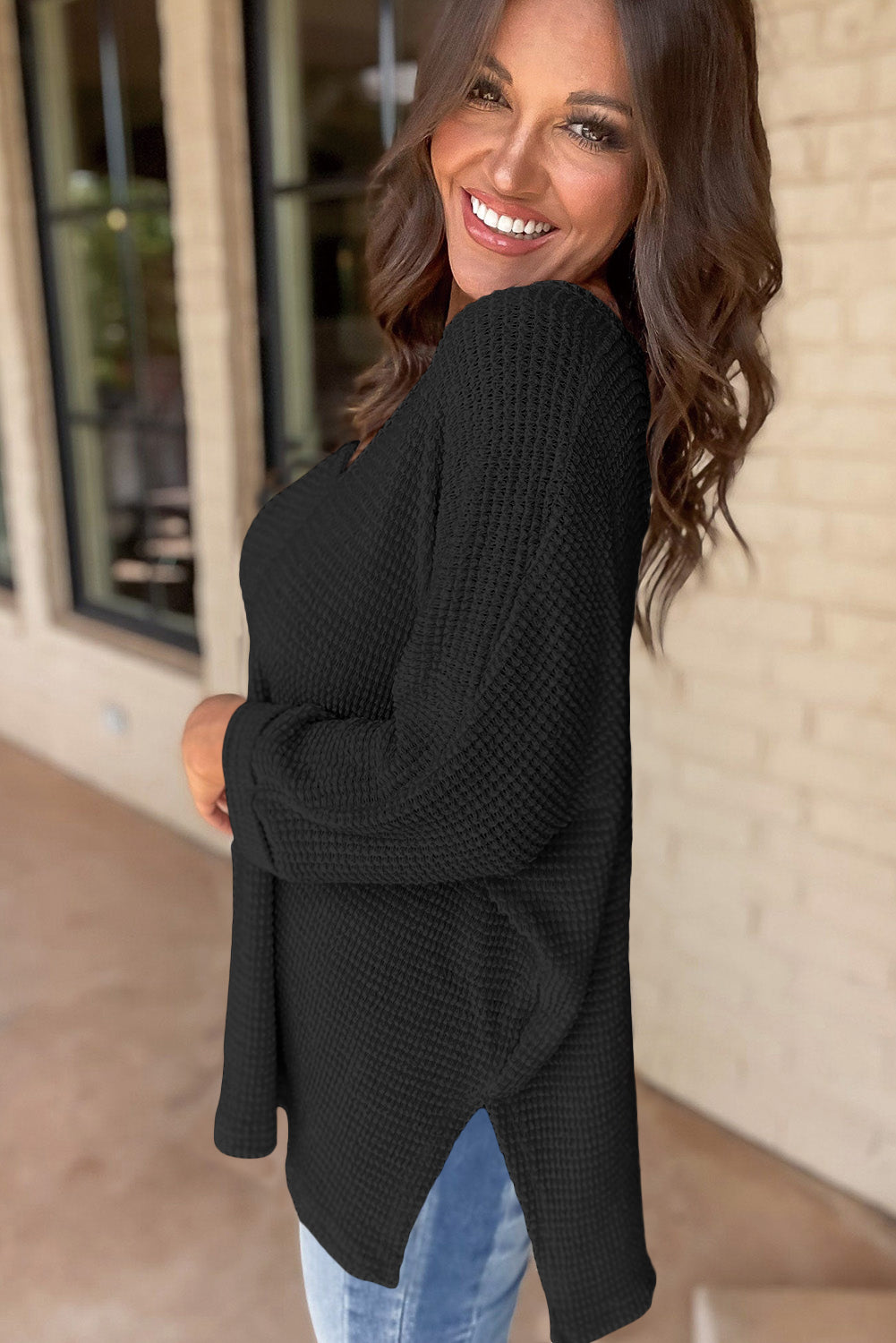 Schwarzes, locker sitzendes Oberteil aus Waffelstrick mit Seitenschlitzen und V-Ausschnitt