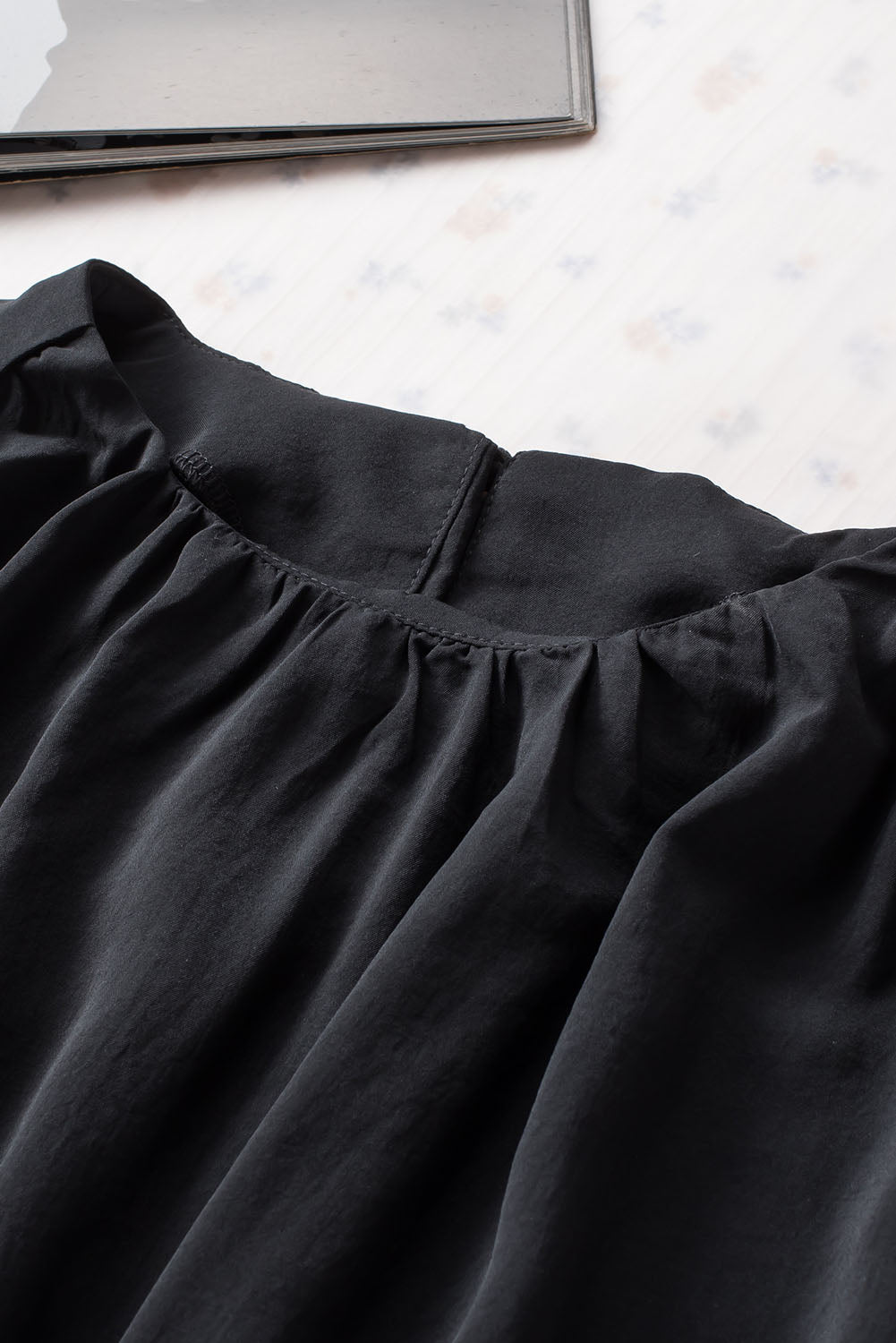 Schwarze, plissierte, lockere Bluse mit gepolsterten Schultern und geknöpften Manschetten