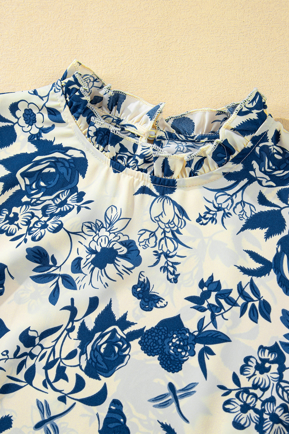 Himmelblaue Bluse mit Blumenmuster, Volantärmeln und Schlüsselloch hinten