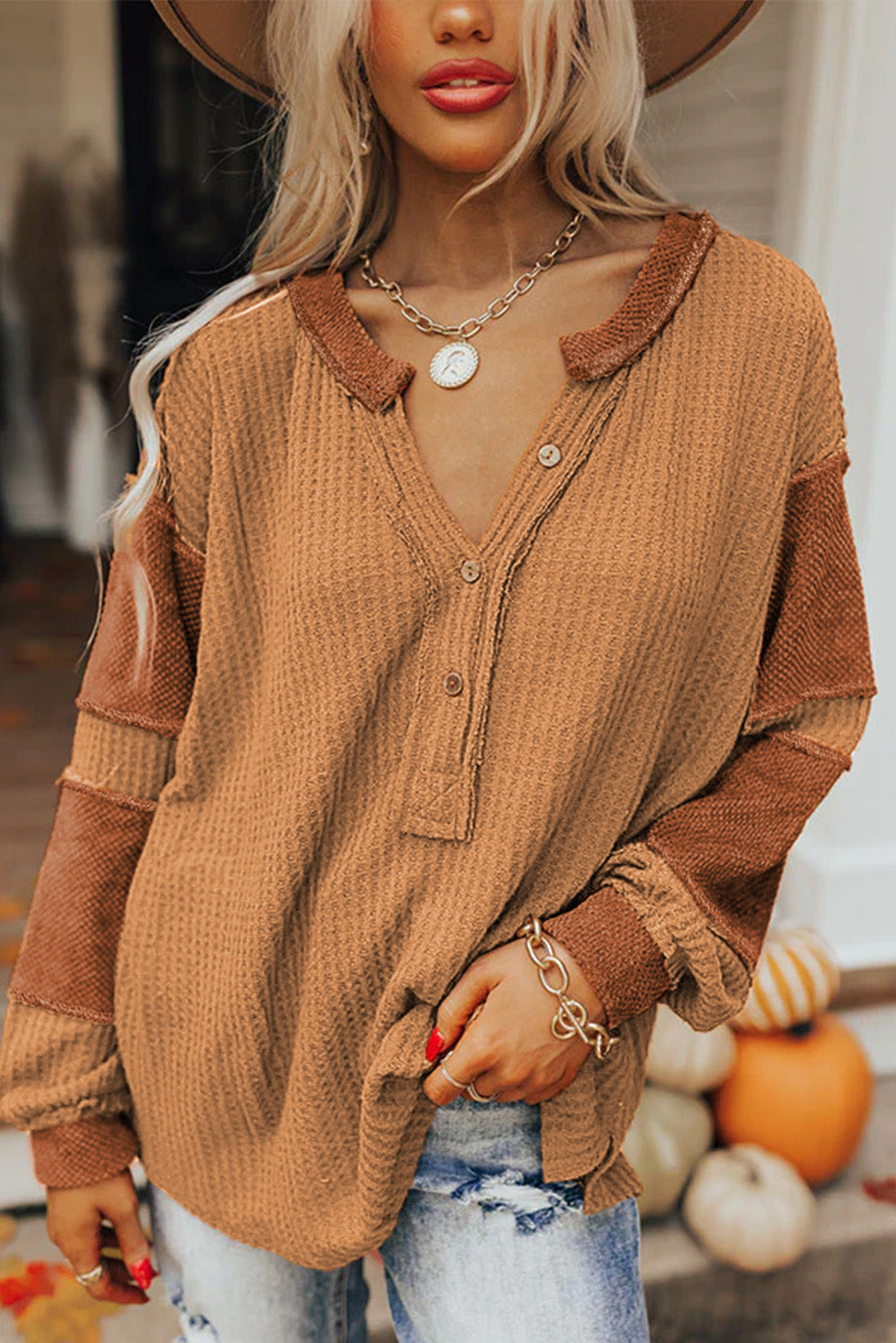 Orangefarbenes Henley-Oberteil aus Waffelstrick mit kontrastierenden Flicken und sichtbaren Nähten