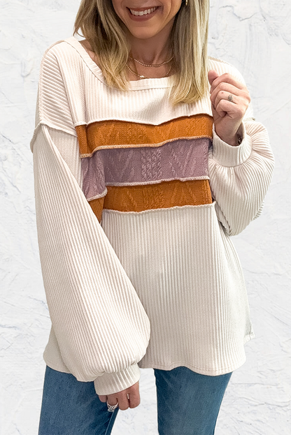 Weißes Stricktop mit Patchwork-Muster und sichtbaren Nähten sowie langen Ärmeln