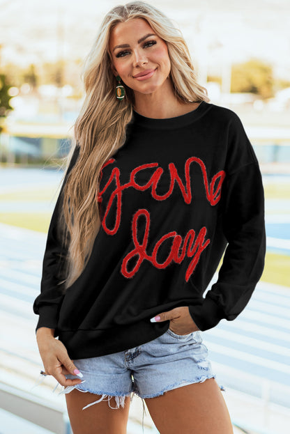 Schwarzes Lametta-Sweatshirt mit Game Day-Grafik und überschnittener Schulter