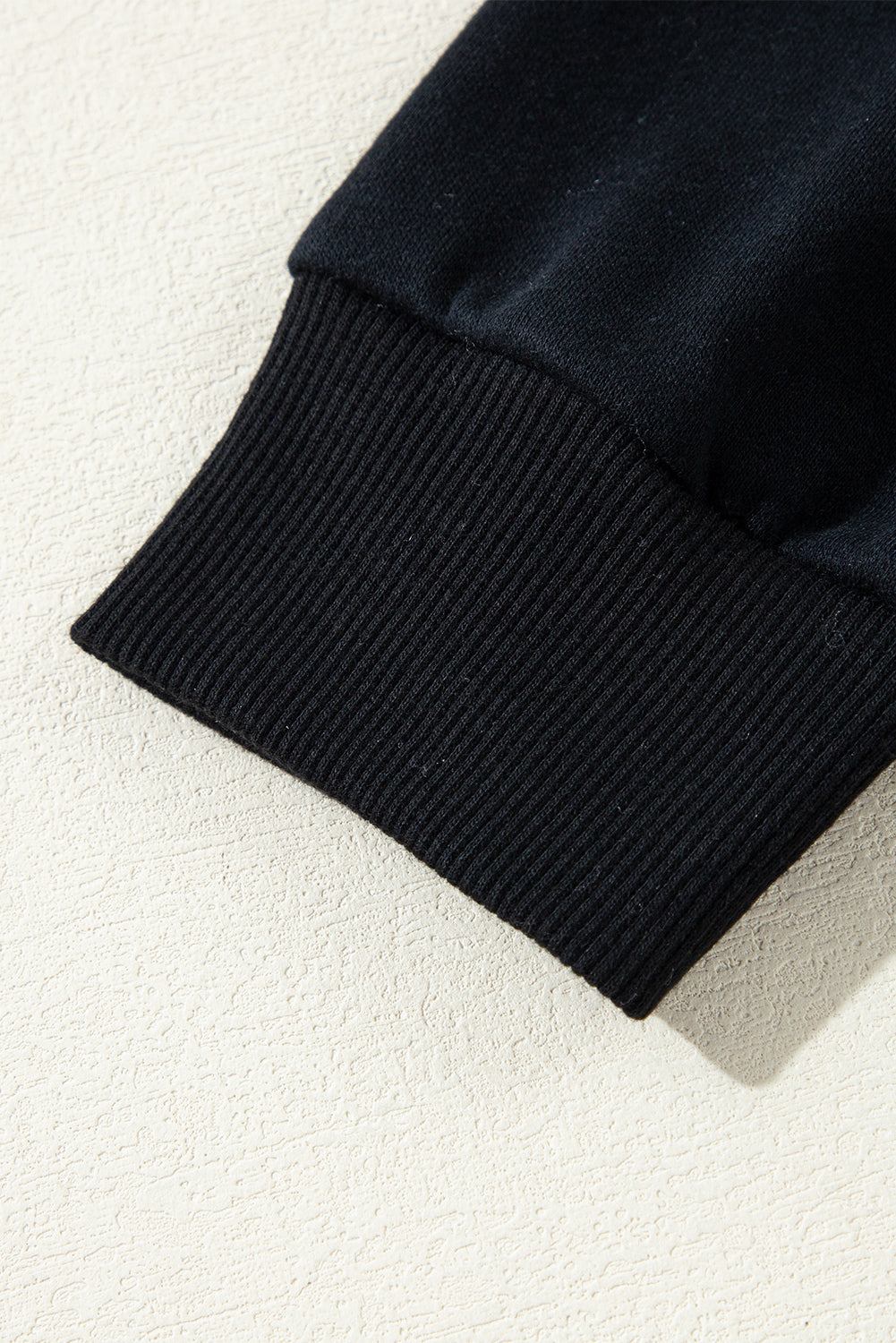Schwarzer, einfarbiger Kapuzenpullover mit Raglanärmeln und Nieten und Tasche