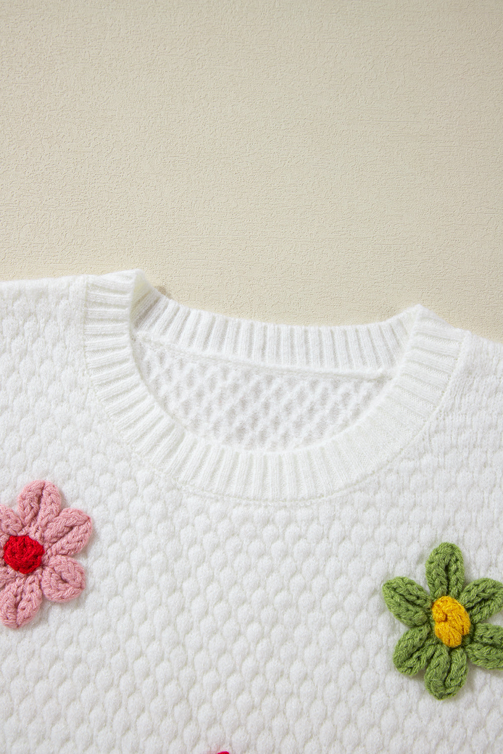 Weißer Strickpullover mit bunter Blumenapplikation