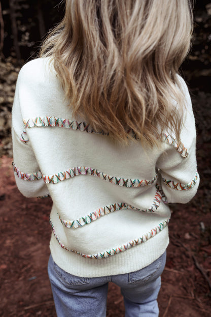 Weißer Pullover mit bunten Kreuzstichen und überschnittenen Schultern
