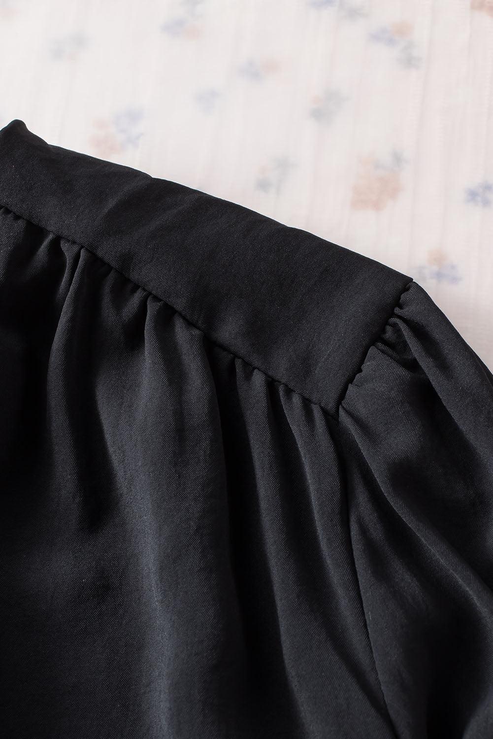 Schwarze, plissierte, lockere Bluse mit gepolsterten Schultern und geknöpften Manschetten