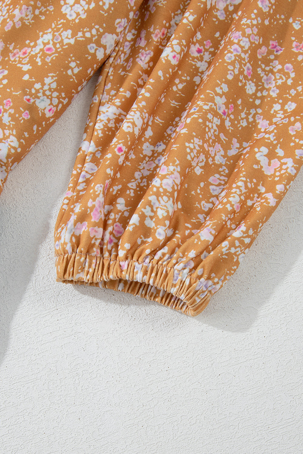 Orangefarbene Bluse mit Blumenmuster, Farbblockdesign, Rüschensaum und Rundhalsausschnitt
