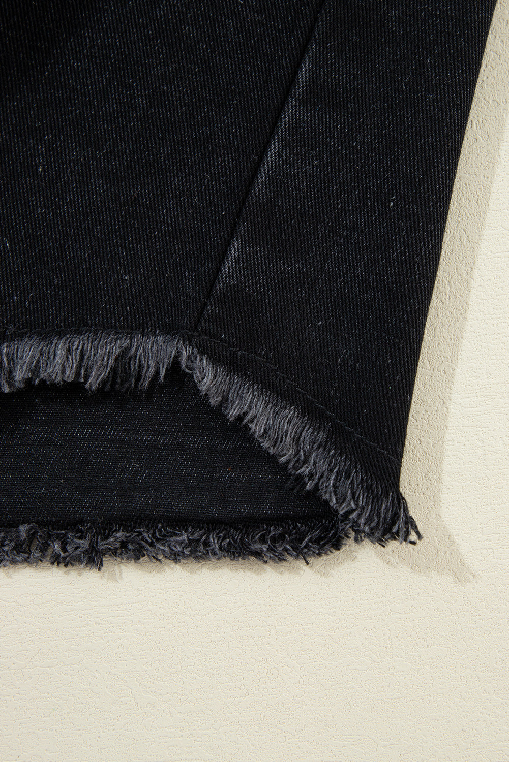 Schwarze Jeansjacke mit Kapuze und karierten Ärmeln und ausgefranstem Saum