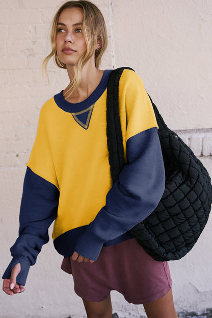 Gelbes Sweatshirt mit Farbblockdesign und Daumenlöchern an den Ärmeln sowie überschnittener Schulter