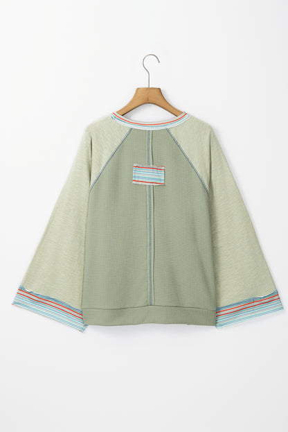 Meadow Mist – Grünes Waffelstrick-Patchwork-Raglan-Top mit breiten Armbandärmeln
